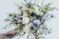 11 an airy wedding bouquet of white roses, blue thistles and berries, eucalyptus is a beautiful idea for a spring or summer wedding