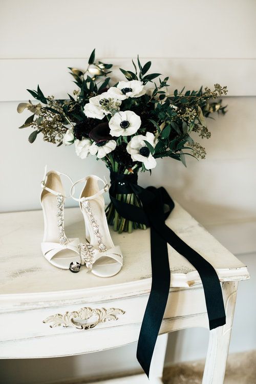 a black and white wedding bouquet of deep purple callas and white anemones, greenery and gilded leave for a NYE wedding