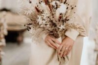 14 a delicate dried wedding bouquet of cotton, bunny tails, berries, twigs, dried foliage and grasses plus ribbons is ideal for fall