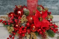 15 a bold Christmas or Christmas wedding centerpiece of red ornaments, berries, gilded pinecones and branches and red poinsettias