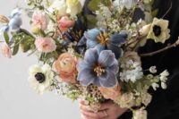 16 a beautiful and delicate pastel wedding bouquet of peachy ranunculus, blue and white blooms, eucalyptus and blooming branches