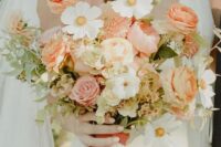 18 a beautiful textural wedding bouquet of orange and pink roses and ranunculus, white blooms and greenery plus dried foliage