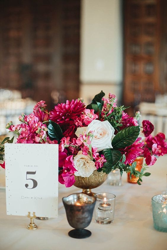 a bright wedding centerpiece with white, magenta blooms and greenery is a cool and bold decor idea to rock