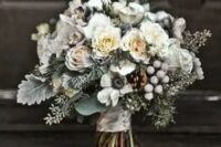 18 a frozen winter wedding bouquet with white blooms, pale greenery, evergreens and berries