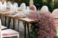 18 a stylish modern wedding reception table decorated with pink baby’s breath and greenery with no foam and pink napkins and pillar candles