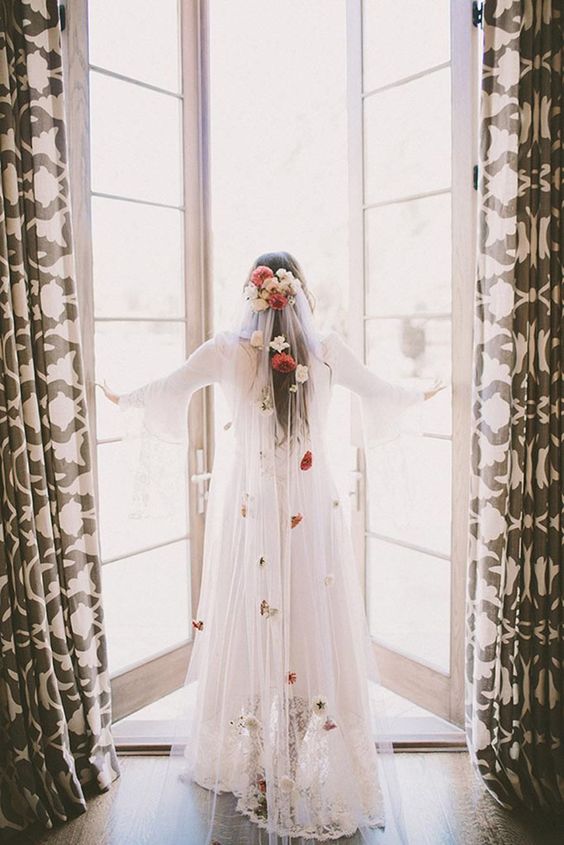 a cathedral veil with white and red fresh and dried blooms is a beautiful accent for a chic and lovely bridal look