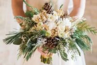 19 a glam and shiny winter wedding bouquet of white blooms, gilded berries, pinecones, evergreens and greenery is a lovely idea