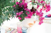 20 a bright wedding tablescape with a bold magenta centerpiece and matching glasses, colorful placemats and blue napkins