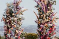 20 a jaw-dropping colorful wedding altar with blooms of all kinds and colors and pampas grass plus a lovely view
