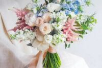 21 a dreamy wedding bouquet of white peonies, blush and white ranunculus, astilbe, blue blooms and blush ribbons for a garden bride