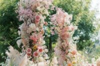 21 a fantastic and super lush wedding arch with pink, yellow and orange blooms and blooming branches plus pink baby’s breath all over