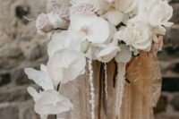22 a jaw-dropping cascading wedding bouquet of white orchids, white and pale pink roses, pampas grass and some twigs