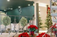 23 a Christmas wedding venue with red poinsettia bouquets lining up the stairs looks absolutely adorable