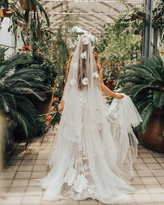 a floral wedding dress and a neutral cathedral veil accented with fresh orchids are a fantastic and very girlish combo for a wedding