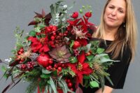 24 a fantastic wedding centerpiece of a red bucket, greenery and evergreens, red berries, pomegranates, poinsettias and LEDs