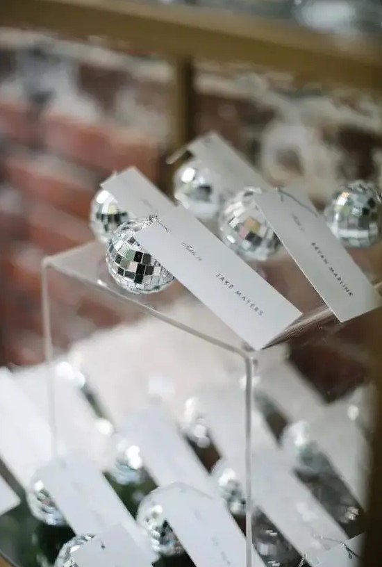 mini disco balls as wedding favors and as place card holders at the same time for a party-themed or a NYE wedding