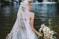 25 a long veil with a faux flower halo on top and pastel-colored faux blooms all over the veil for a catchy and very romantic bridal look