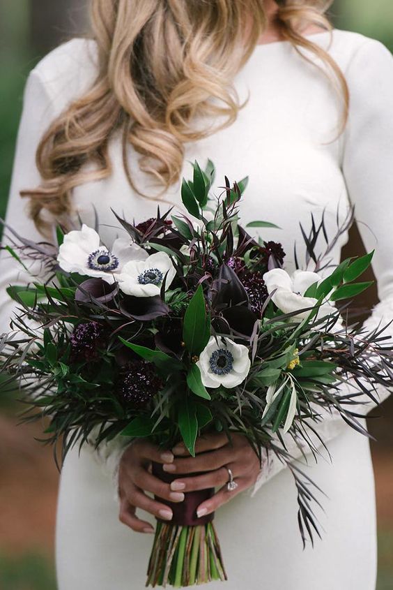 a stylish NYE wedding bouquet of white anemones and deep purple callas, dark leaves and greenery is a bold idea