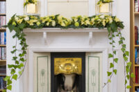 28 a wedding fireplace dressed up with golden poinsettias and traipsing ivy leaves for a super elegant look