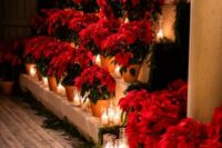 30 bold Christmas wedding decor with red poinsettias in planters and pillar candles plus evergreens is a lovely idea