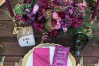 31 a sophisticated wedding tablescape with gold chargers and cutlery, with bright pink and magenta blooms, matching napkins and tall and thin candles
