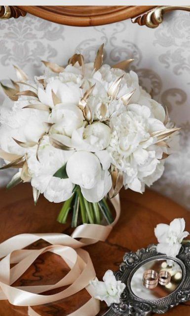 a white peony wedding bouquet with gilded leaves and ribbon is a lovely and pretty idea for a NYE wedding