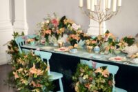 32 leafy chair decorations scattered with loose fern-like sprigs and peach-colored poinsettias offer an air of botanical garden magic