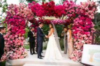 35 a lush and bold wedding arch covered with pink, hot pink and fuchsia blooms is a fantastic decor idea for a bold wedding
