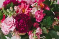 37 a lush and dimensional wedding centerpiece of fuchsia and hot pink blooms, light pink flowers and greenery for a bright wedding