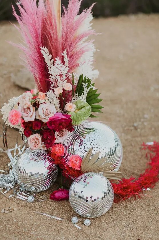 a super bold wedding arrangement of blush and bold blooms, pampas grass, greenery and disco balls by it looks wow