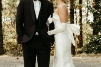 42 a modern sophisticated bridal look with a strapless plain wedding dress with a big bow on the back and matching long gloves plus pearl earrings