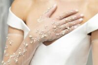 45 a chic modern wedding dress with a deep neckline and sheer long gloves with pearls and rhinestones are a lovely combo