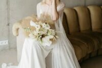 47 a delicate modern bridal look with a white slip maxi wedding dress, a semi sheer capelet with a train, clear shoes