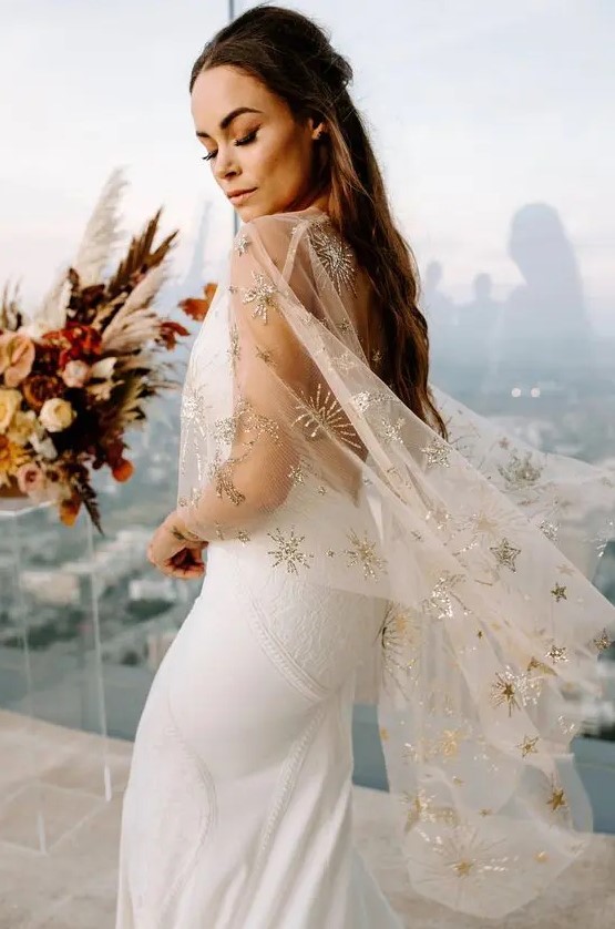 a sophisticated clear bridal capelet with celestial gold embroidery is a beautiful accessory to rock, it looks amazing