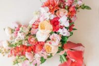 55 an ultimately bold wedding bouquet of pink, red, peachy and white blooms, greenery, pink and red ribbons