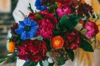 58 a bold wedding bouquet with fuchsia, red, blue, yellow flowers, privet berries and foliage for a bright fall wedding