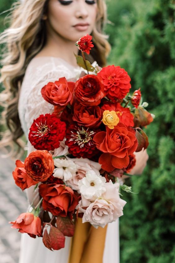 a fantastic fall wedding bouquet of red blooms and some white and blush ones, with leaves of bold colors is amazing