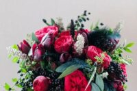 64 a sumptuous fall wedding bouquet of deep purple, pink and red blooms, lots of privet berries and greenery plus feathers for a fall bride