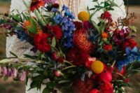 65 a fantastic jewel tone wedding bouquet with red, orange, blue, lilac blooms, greenery, billy balls and much texture