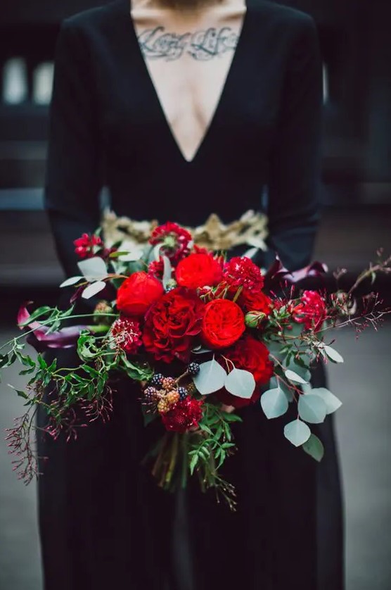 a super colorful Halloween wedding bouquet with red and dark purple blooms plus berries and greenery