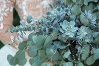70 a pale green cascading wedding bouquet with eucalyptus, succulents and blue thistles for a fairy-tale feel