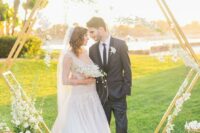 a beautiful hex spring wedding arch with white blooms, candles and geometric hangings with white florals