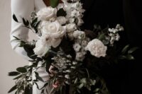 a black and white dimensional and textural wedding bouquet of white roses and other blooms, some black touches and greenery