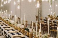a black and white wedding tablescape with gold touches, white blooms and bulbs over the table