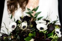 a bold and contrasting wedding bouquet of white anemones and dark dahlias, greenery and textural dark foliage is wow
