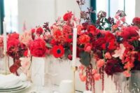 a bold red floral centerpiece – a box with bright blooms and leaves and some neutral candles for a chic look