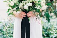 a bold wedding bouquet of white ranunculus and roses, dark dahlias and greenery plus some cascading touch