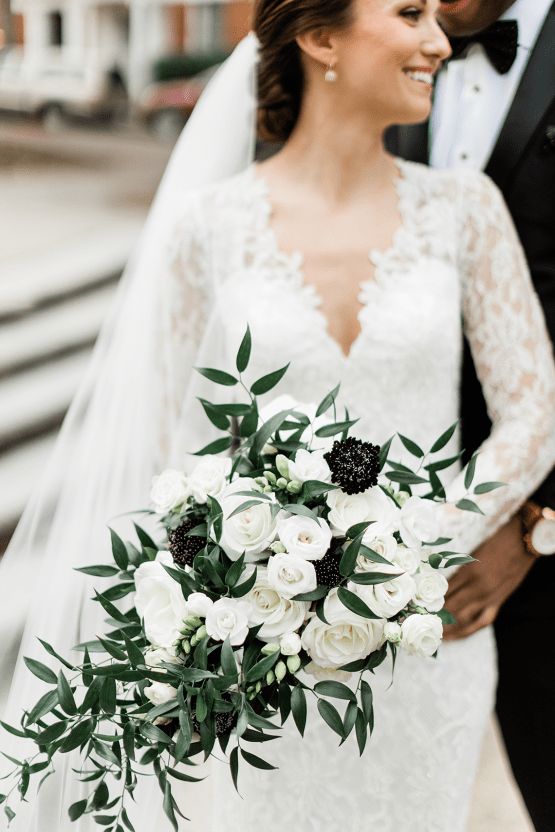 a breezy wedding bouquet of white roses and black dahlias plus some greenery is a cool and fresh idea