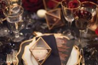 a bright NYE wedding tablescape with a black sequin tablecloth, red roses, gold-rimmed glasses and plates is amazing