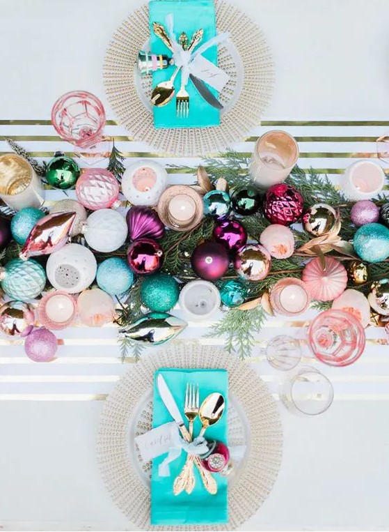 a colorful and glitter ornament table runner on fir branches and ornaments for each place setting are great for a colorful NYE wedding